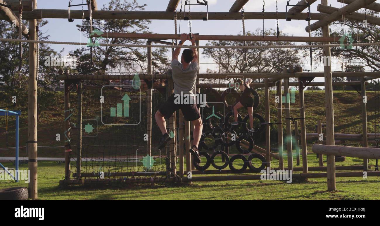 Anneaux de gymnastique de préhension, athlète masculin se balançant le long d'un cadre en bois au parcours d'obstacles extérieur Banque D'Images