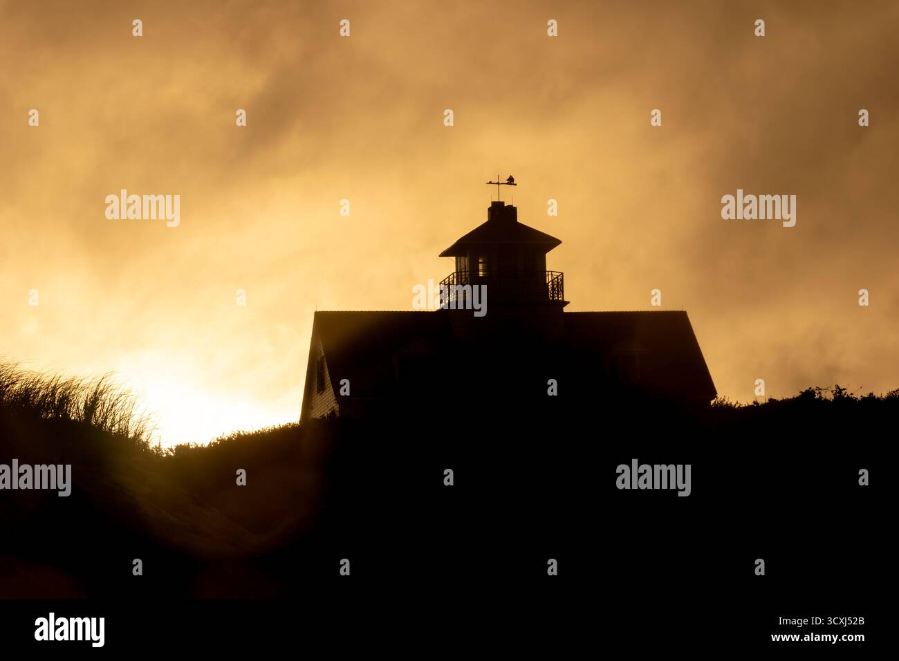 Golden Hour sur la plage ! Herbe de dune et silhouette de chalet contre un ciel dramatique. Vacances paisibles en bord de mer Banque D'Images
