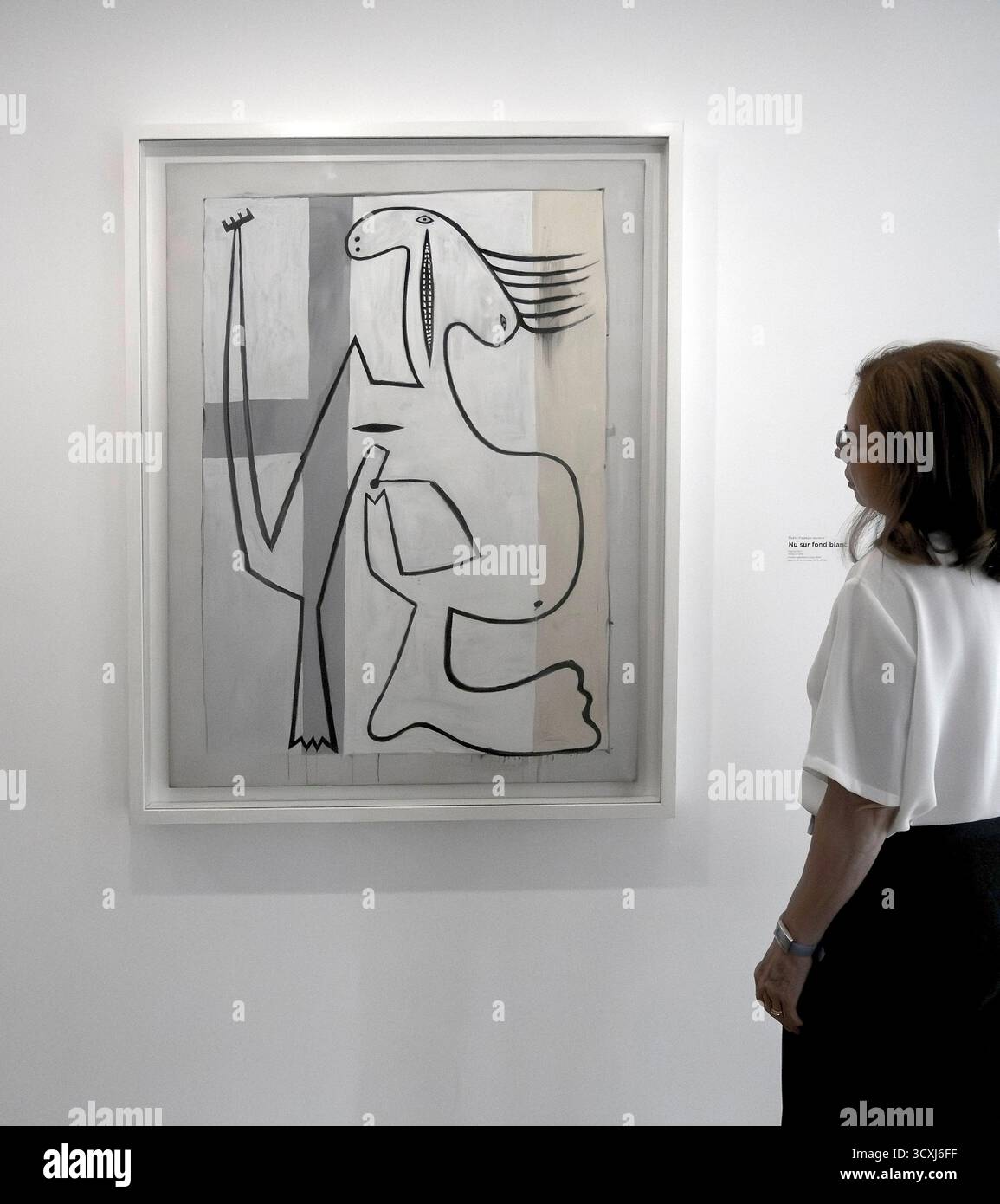 Femme regardant la peinture de Pablo Picasso Nu sur fond Blanc 1927 au Musée Picasso, Marais, Paris, France Banque D'Images