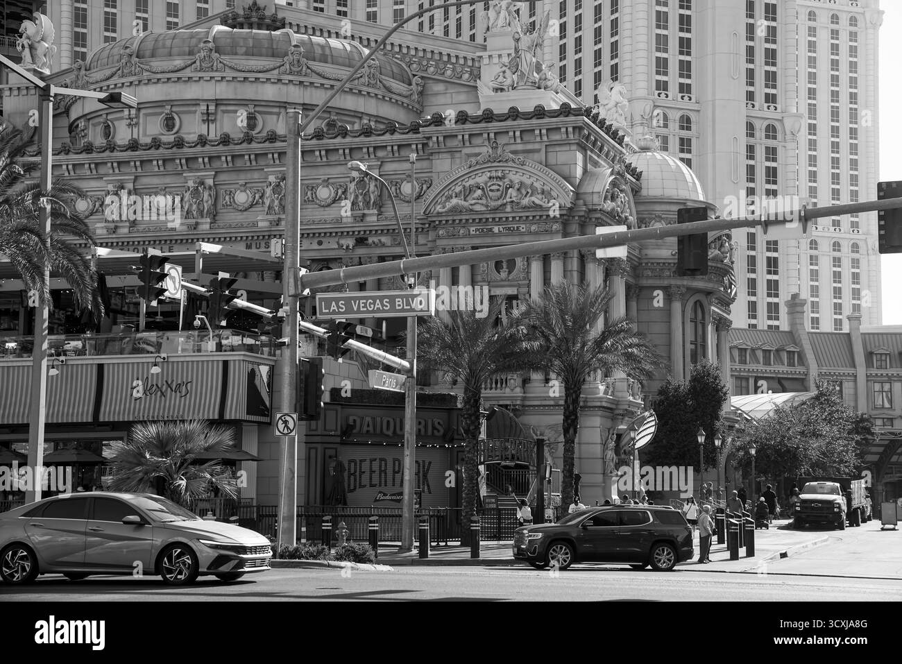 Scène de rue en noir et blanc du Paris Las Vegas Hotel montrant une architecture classique et des palmiers à l'intersection du Las Vegas Boulevard Banque D'Images