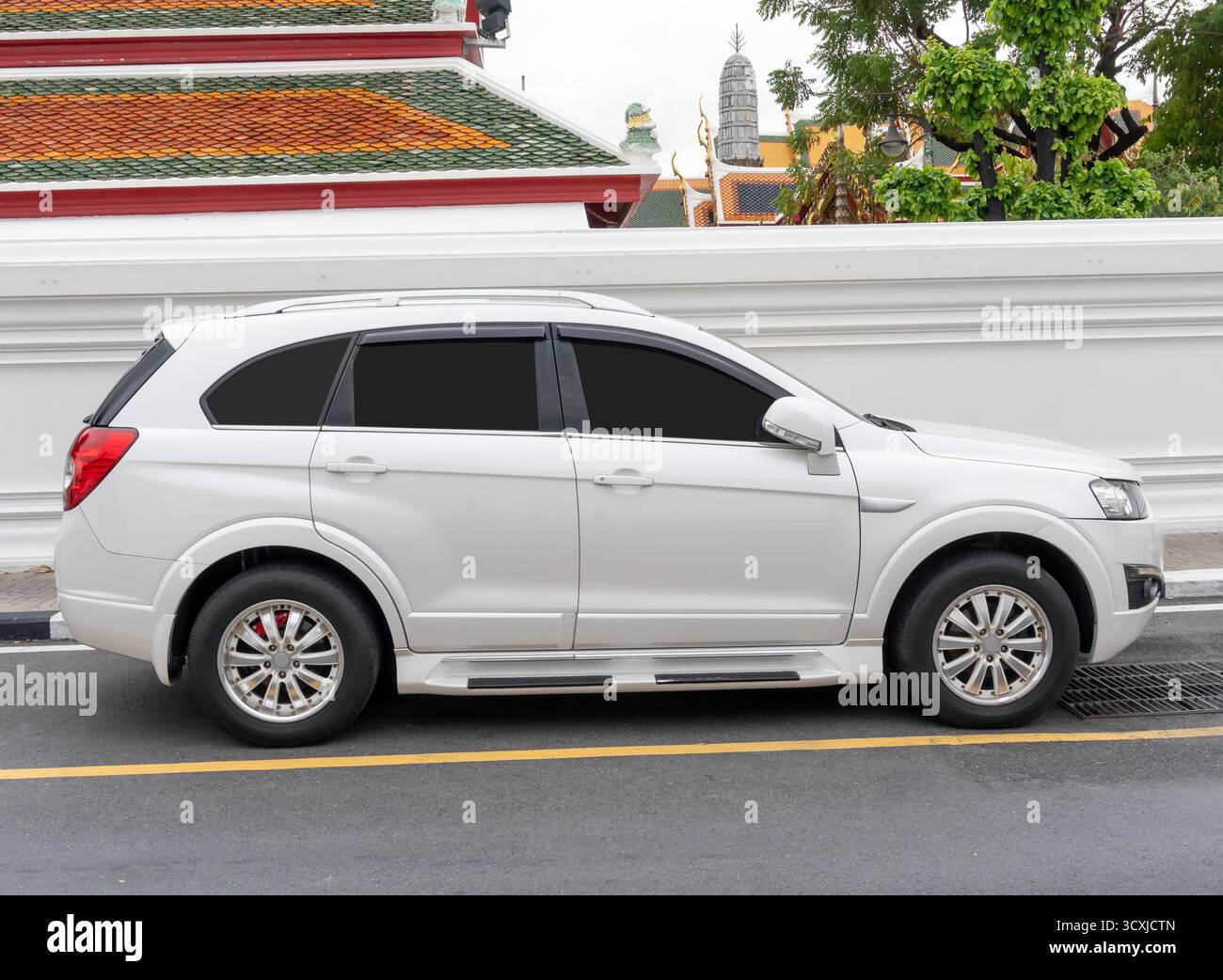 White SUV voiture de sport est parking sur le côté de la route près du sentier piéton d'un temple à Bangkok en Thaïlande. Banque D'Images