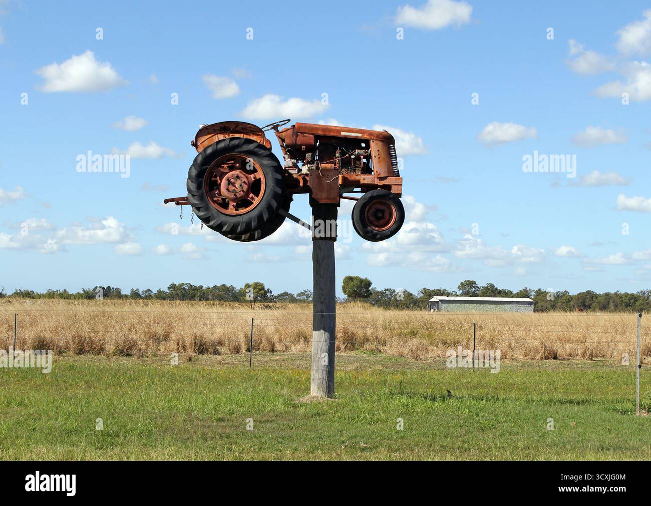 South Kolan, Queensland, Australie - 11 juin 2024 : vieux tracteur monté sur un poteau en bois dans le cadre de l'attraction touristique Jim's Row of Machinery Banque D'Images