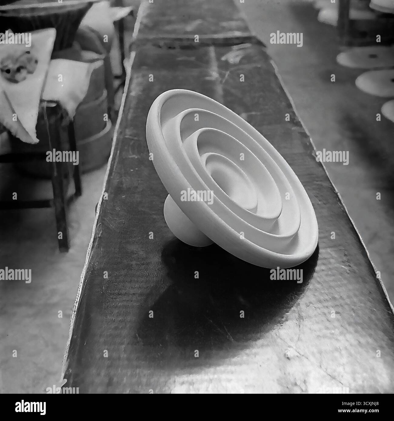 Une photo d'archives frappante des années 1980 capture une étape dans le processus de production de porcelaine à l'usine de raccords et isolateurs Sloviansk (AIZ). L'image est un gros plan détaillé d'un isolant électrique haute tension dans sa forme brute, non émaillée. Sa forme géométrique parfaite repose sur un banc d'atelier, en attendant la prochaine étape. Cette photo symbolise la précision et la puissance industrielle de l'ère soviétique. C'est un document précieux du travail créatif qui a défini le Donbass pacifique avant la guerre Banque D'Images