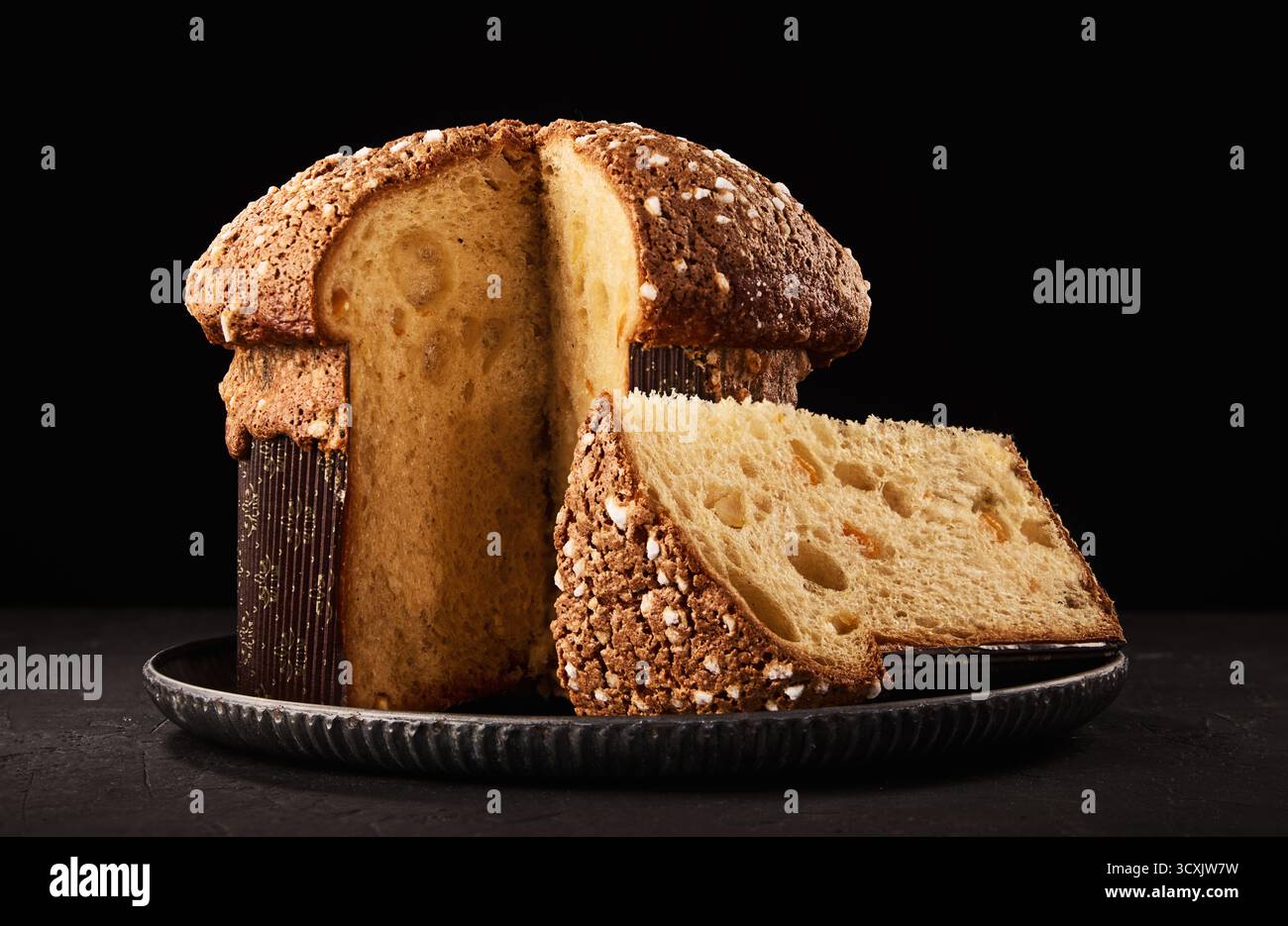 Panettone gâteau italien de Noël, pain doux traditionnel sucré avec des noix, des raisins secs et du chocolat sur fond noir Banque D'Images
