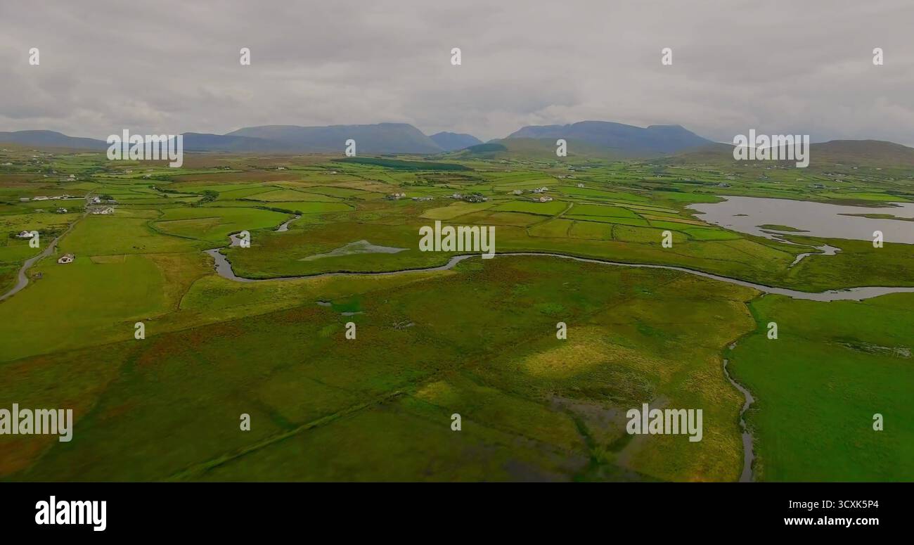 Ruisseau sinueux coulant à travers les champs verdoyants dans la vallée, avec des murs de pierre haies et des fermes Banque D'Images