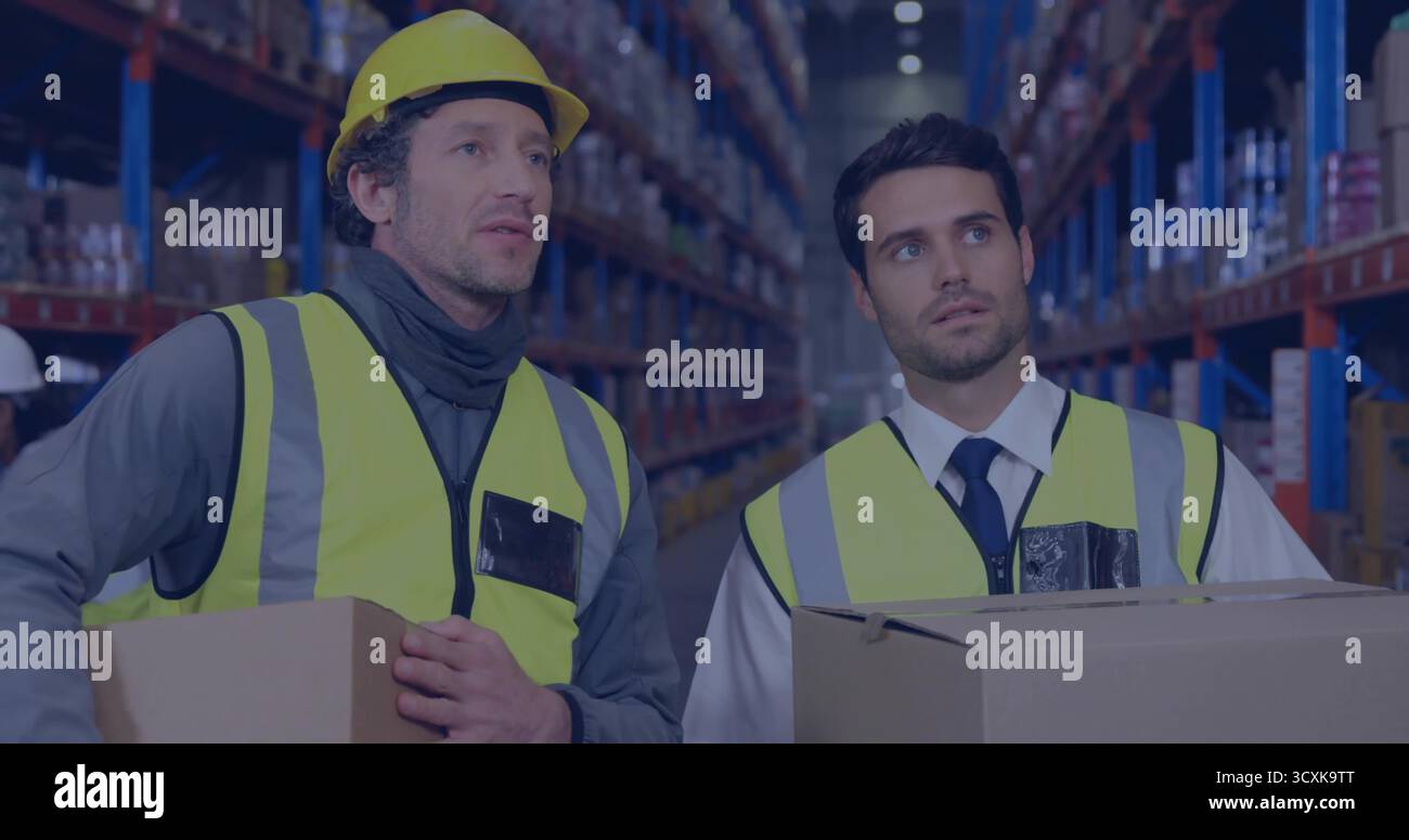 Inspecter les boîtes en carton sur les étagères de l'entrepôt, deux hommes portant des gilets réfléchissants et des casques de sécurité Banque D'Images