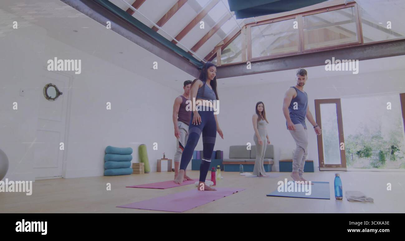 Camarades de classe de yoga dans des équipements d'entraînement pratiquant des poses dans un studio de fitness, avec des tapis colorés, couronne de porte Banque D'Images