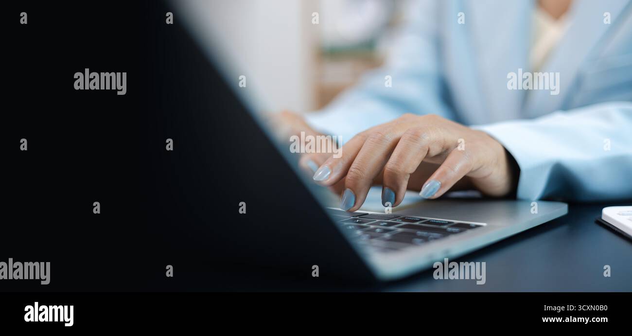 Gros plan des mains de femme d'affaires tapant sur ordinateur portable dans le bureau, concept de travail professionnel, de communication technologique et de style de vie d'affaires numérique. Banque D'Images
