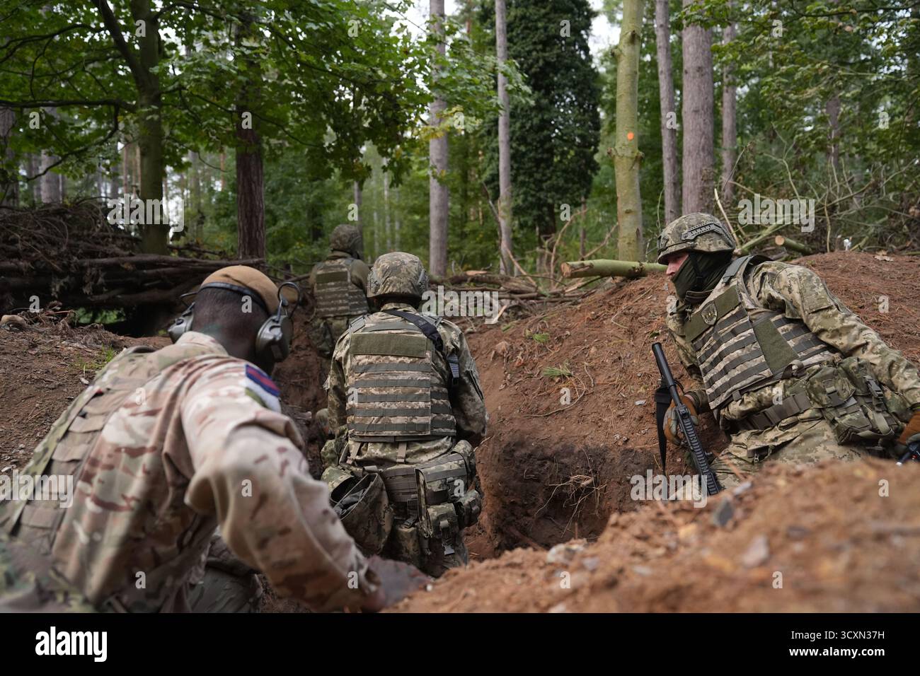 Les soldats ukrainiens, qui suivent encore leur formation de leadership dans le cadre de l’opération Interflex dirigée par le Royaume-Uni, participent à une formation en tranchées dispensée par des membres des gardes irlandais dans un camp d’entraînement de l’armée britannique dans l’est de l’Angleterre. Date de la photo : mercredi 15 octobre 2025. Banque D'Images