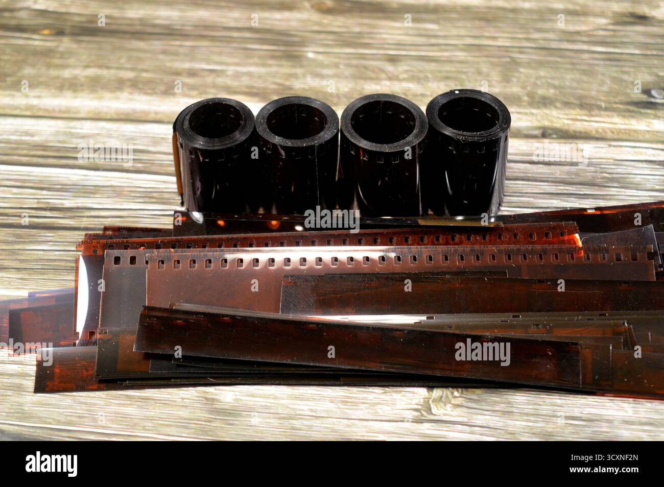 plusieurs rouleaux de film de 35 mm et des bandes de négatifs de film développé, le film photographique est une feuille de plastique enduite d'une émulsion sensible à la lumière cont Banque D'Images