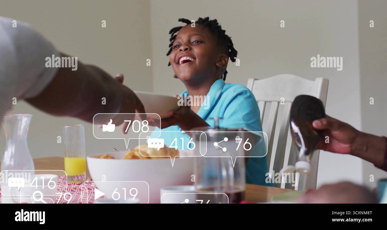 Enfant souriant portant un polo turquoise atteignant le bol à la table à manger familiale, avec bouteille pressable Banque D'Images