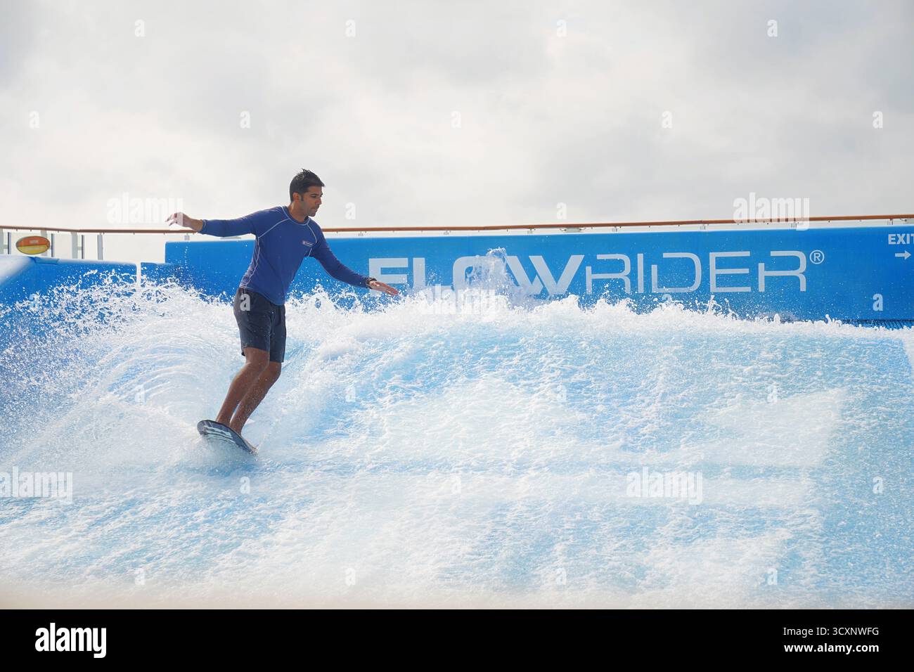 Un homme monte sur le simulateur de surf FlowRider à bord de l’allure of the Seas de Royal Caribbean, présentant l’une des attractions emblématiques du navire Banque D'Images