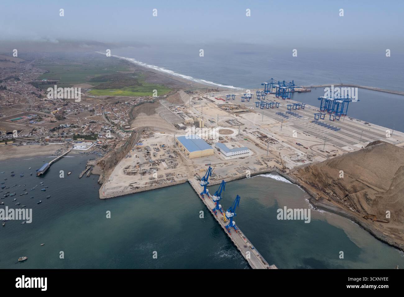 Un méga port de Chancay. Un ciel bleu et blanc avec une ville en arrière-plan. La ville est proche de l'océan et dispose d'un grand port Banque D'Images Un méga port de Chancay. Un ciel bleu et blanc avec une ville en arrière-plan. La ville est proche de l'océan et dispose d'un grand port Banque D'Images