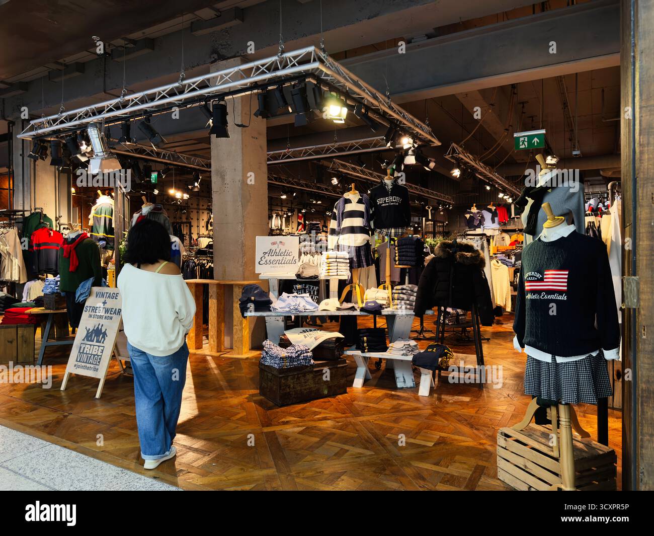 Manchester, Royaume-Uni - 26 septembre 2025 : une boutique de mode Tribe Vintage animée présentant des tenues vintage et modernes dans un espace commercial chaleureusement éclairé. Banque D'Images