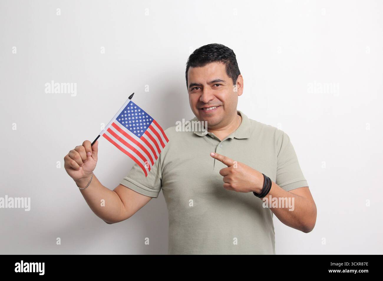 L'homme adulte latino à la peau foncée arbore le drapeau des États-Unis, sa nouvelle nationalité en tant que migrant Banque D'Images L'homme adulte latino à la peau foncée arbore le drapeau des États-Unis, sa nouvelle nationalité en tant que migrant Banque D'Images