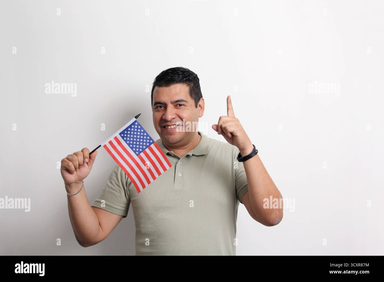L'homme adulte latino à la peau foncée arbore le drapeau des États-Unis, sa nouvelle nationalité en tant que migrant Banque D'Images L'homme adulte latino à la peau foncée arbore le drapeau des États-Unis, sa nouvelle nationalité en tant que migrant Banque D'Images