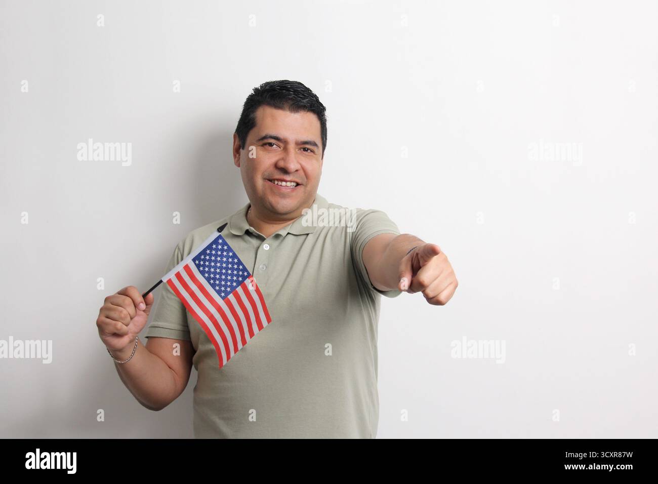 L'homme adulte latino à la peau foncée arbore le drapeau des États-Unis, sa nouvelle nationalité en tant que migrant Banque D'Images L'homme adulte latino à la peau foncée arbore le drapeau des États-Unis, sa nouvelle nationalité en tant que migrant Banque D'Images