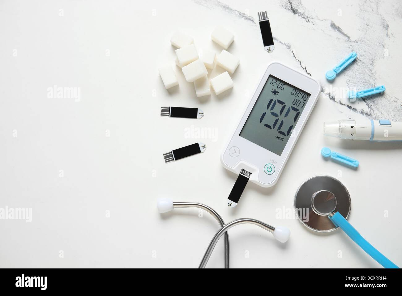 Glucomètre avec stylo lancette, bandelettes de test, cubes de sucre et stéthoscope sur fond de marbre Banque D'Images
