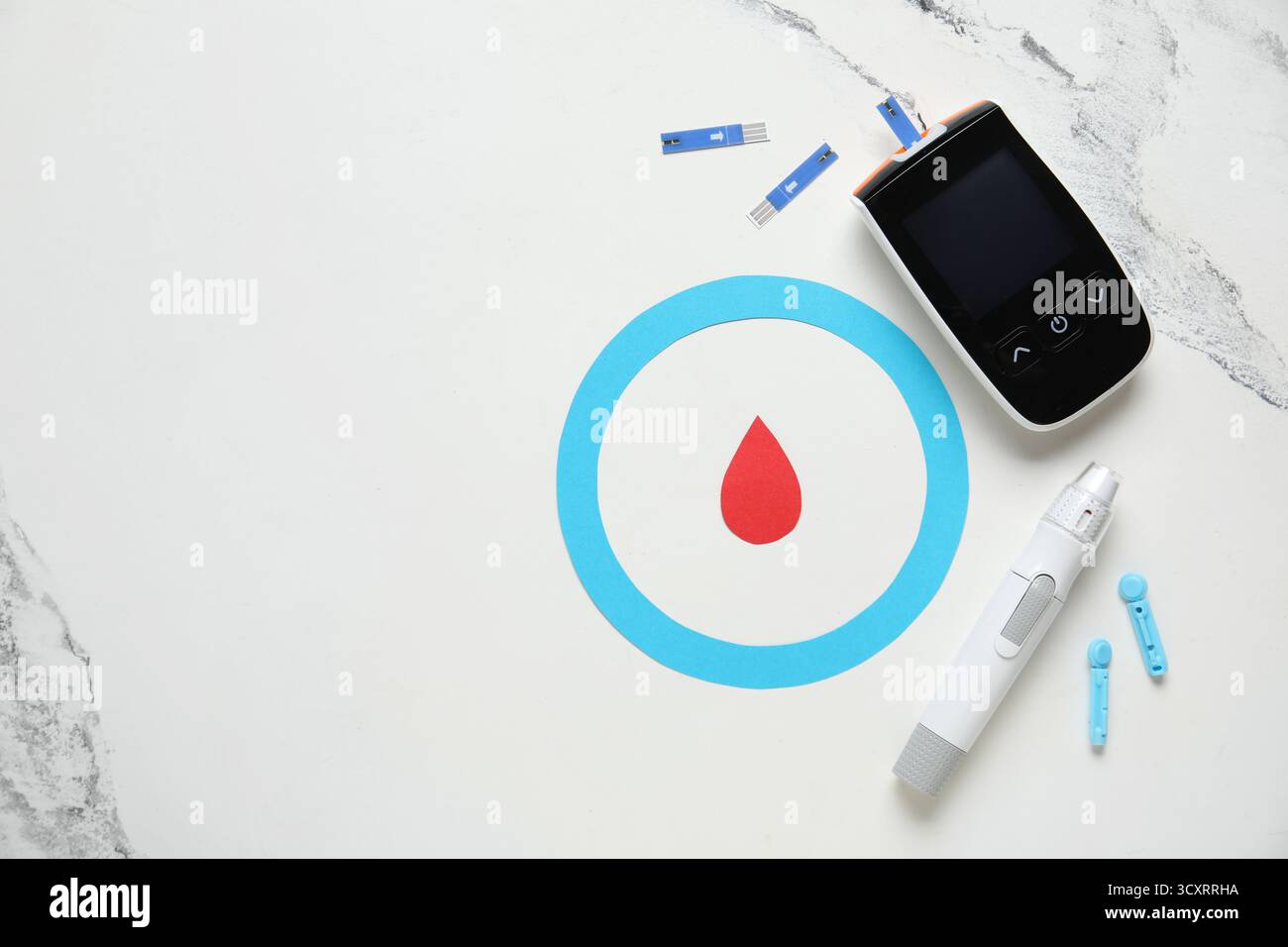Glucomètre avec stylo lancette, bandelette de test, anneau bleu et goutte de sang sur fond de marbre Banque D'Images