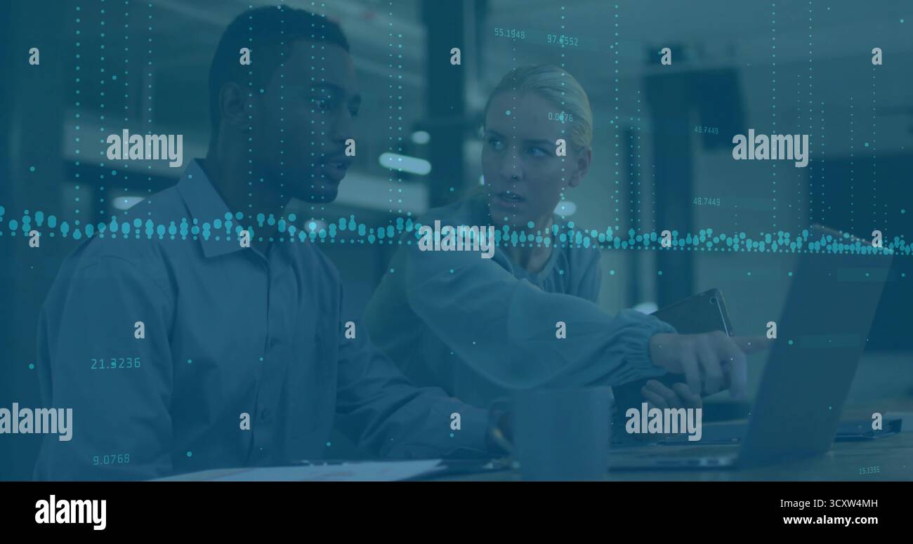 Tenir la tablette et faire des gestes vers l'écran de l'ordinateur portable des collègues discutant de la superposition de données au bureau Banque D'Images