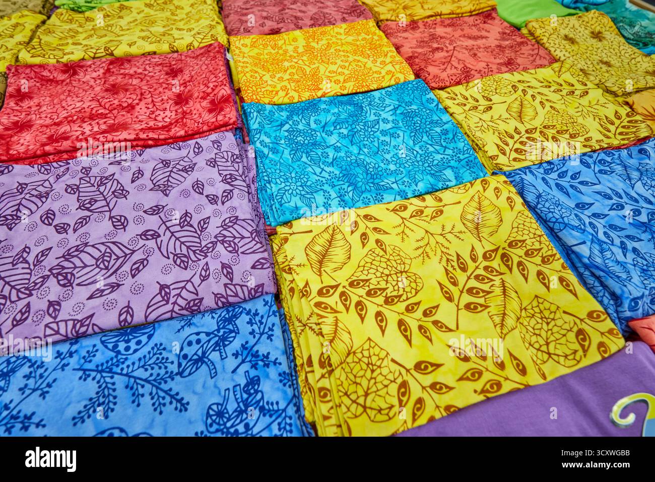 Sélection colorée de vêtements en tissu de bambou pliés et exposés dans une boutique de cadeaux. Kuta, Bali, Indonésie. Banque D'Images