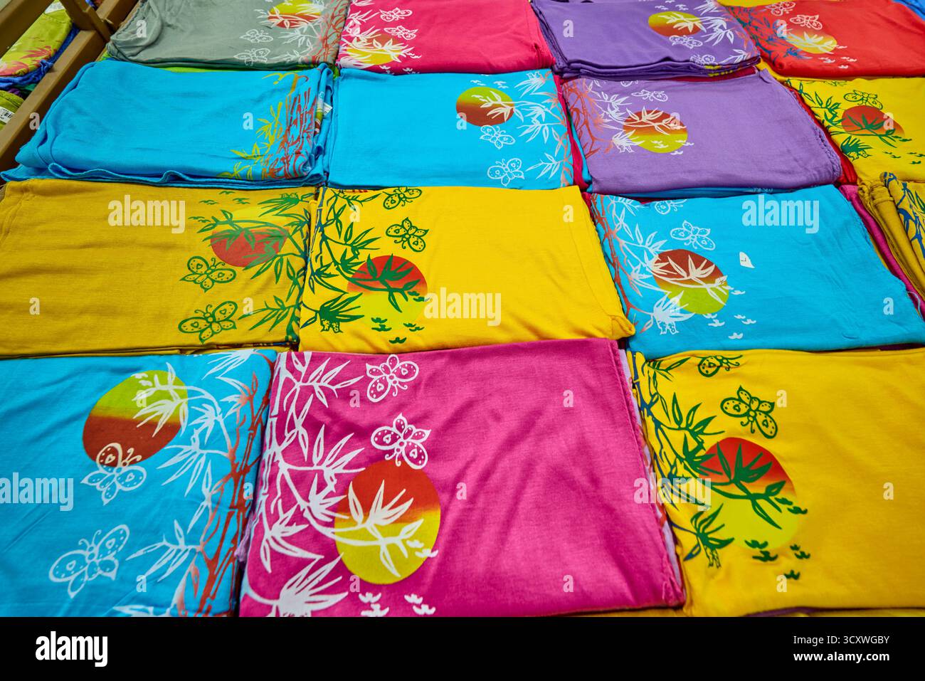 Sélection colorée de vêtements en tissu de bambou pliés et exposés dans une boutique de cadeaux. Kuta, Bali, Indonésie. Banque D'Images