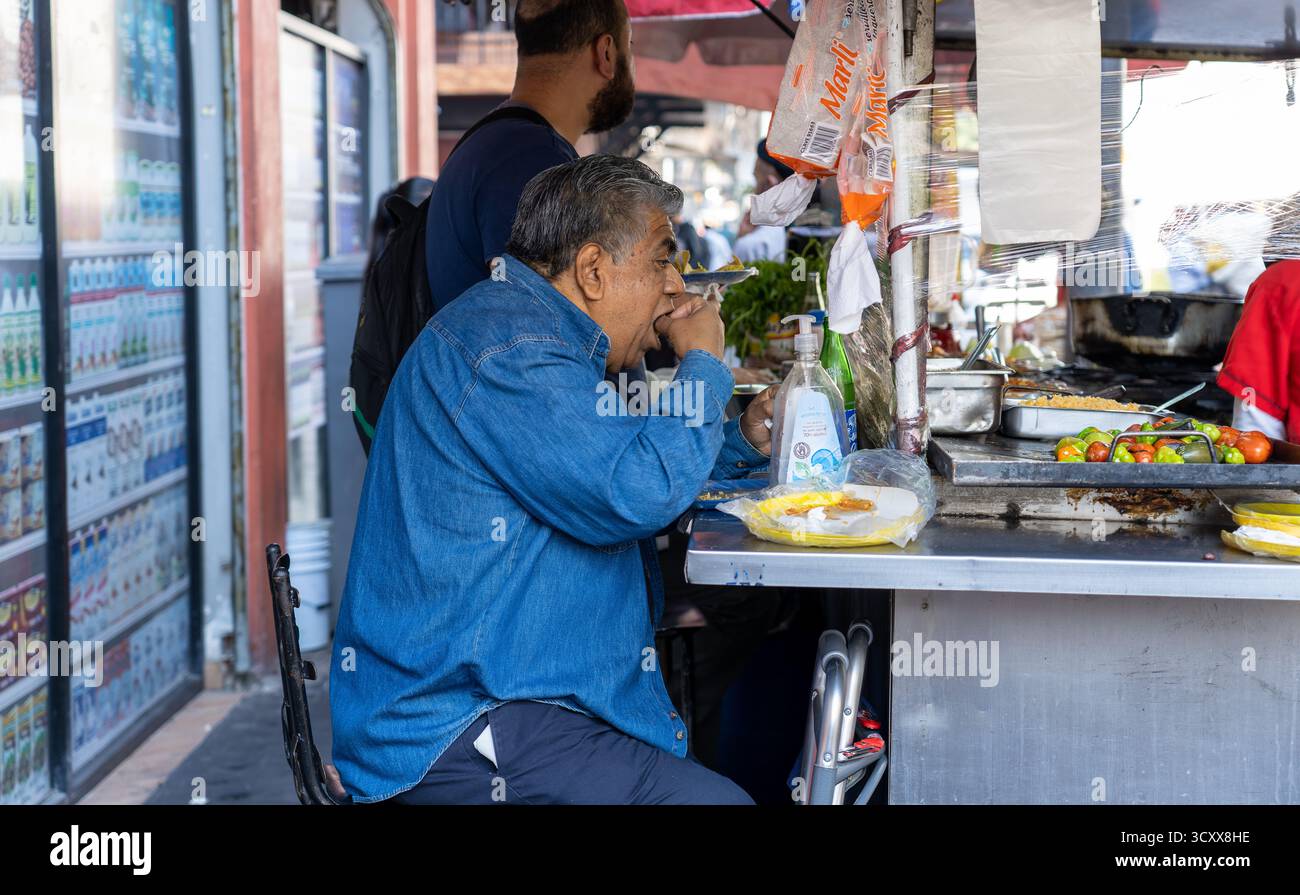 Mexico Mexique - 15 février 2022 : un homme assis à manger dans un chariot de nourriture à Mexico Banque D'Images