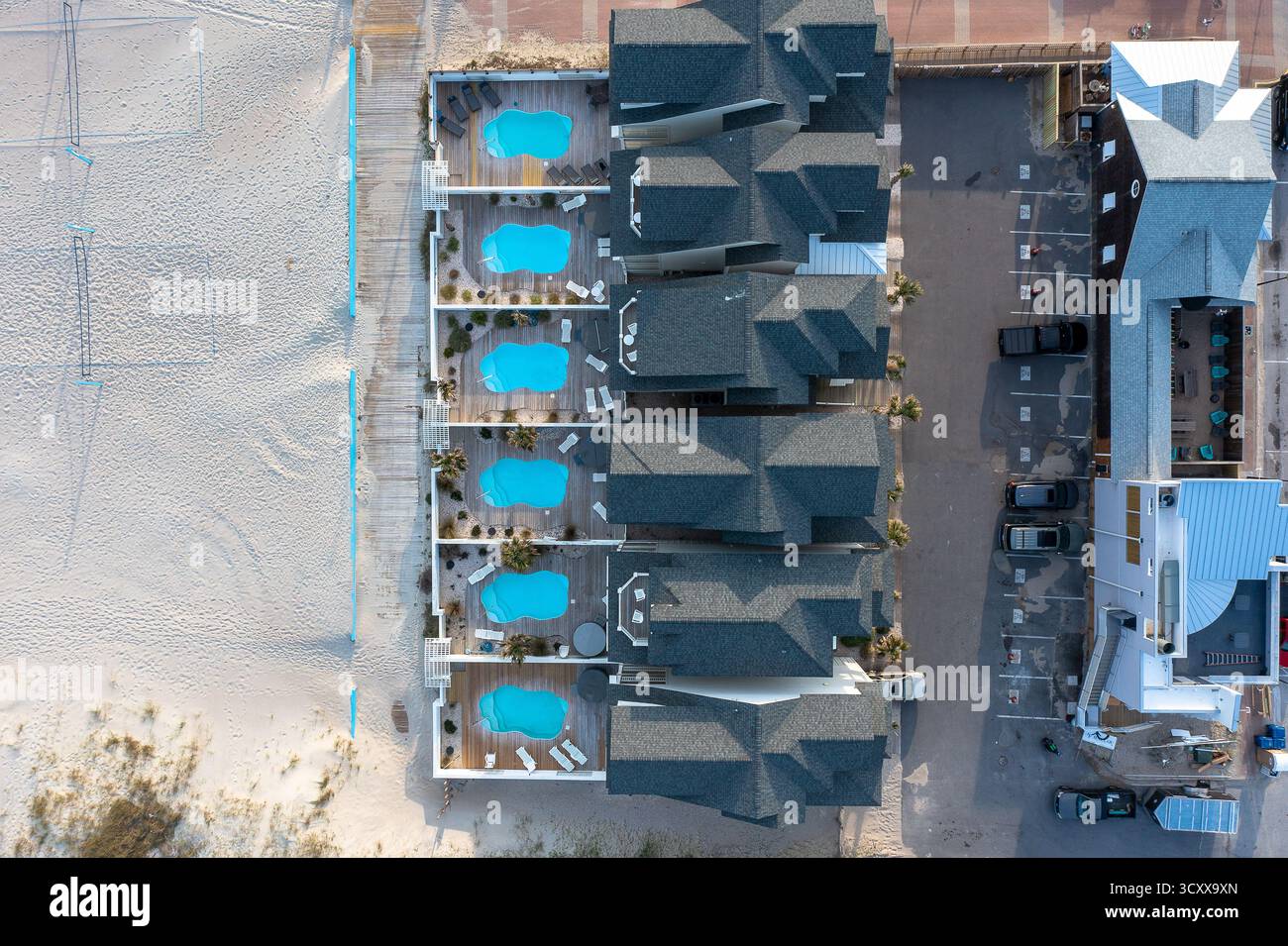 Vue aérienne de haut en bas des maisons de plage chacune avec une piscine à droite sur le sable Banque D'Images