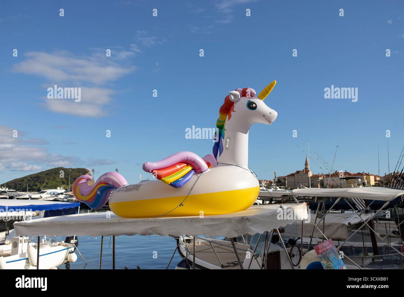 Jouet gonflable de piscine licorne affiché sur le toit d'un bateau dans la marina de Budva, Monténégro, sur une journée d'été ensoleillée. Banque D'Images