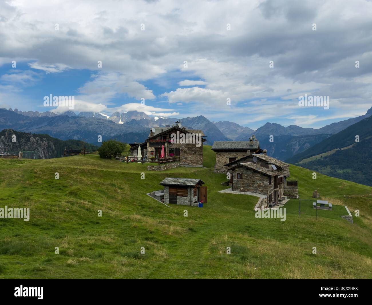 Les chalets de l'Alpe Piasci à Valmalenco. La gamme BERNINA en arrière-plan. Banque D'Images