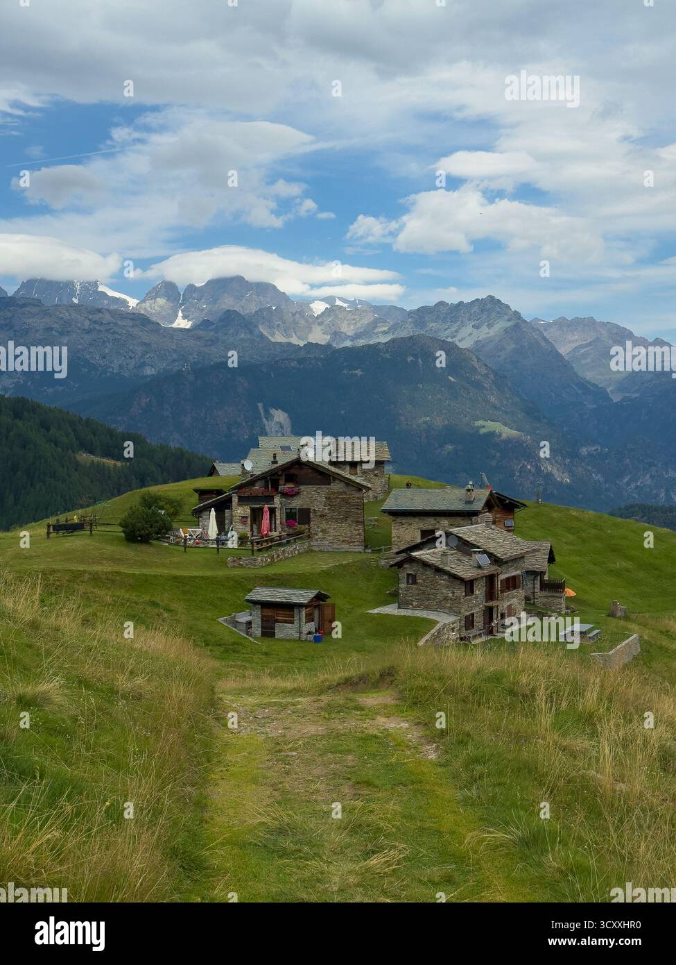 Les chalets de l'Alpe Piasci à Valmalenco. La gamme BERNINA en arrière-plan. Banque D'Images