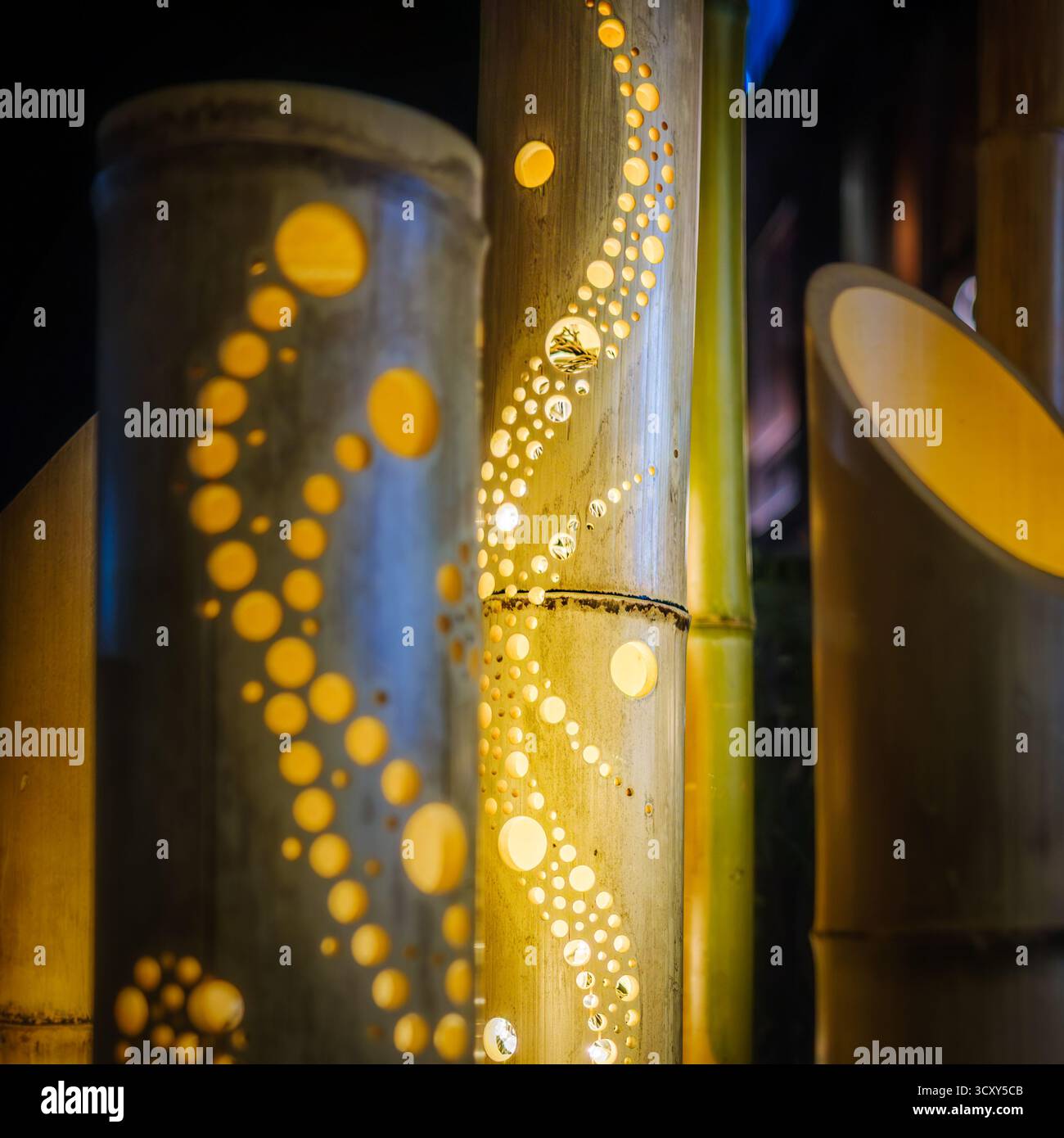 Lanternes en bambou illuminées qui brillent chaleureusement dans la nuit lors d'un festival d'été japonais. Des motifs artisanaux de trous circulaires forment des dessins artistiques, c Banque D'Images