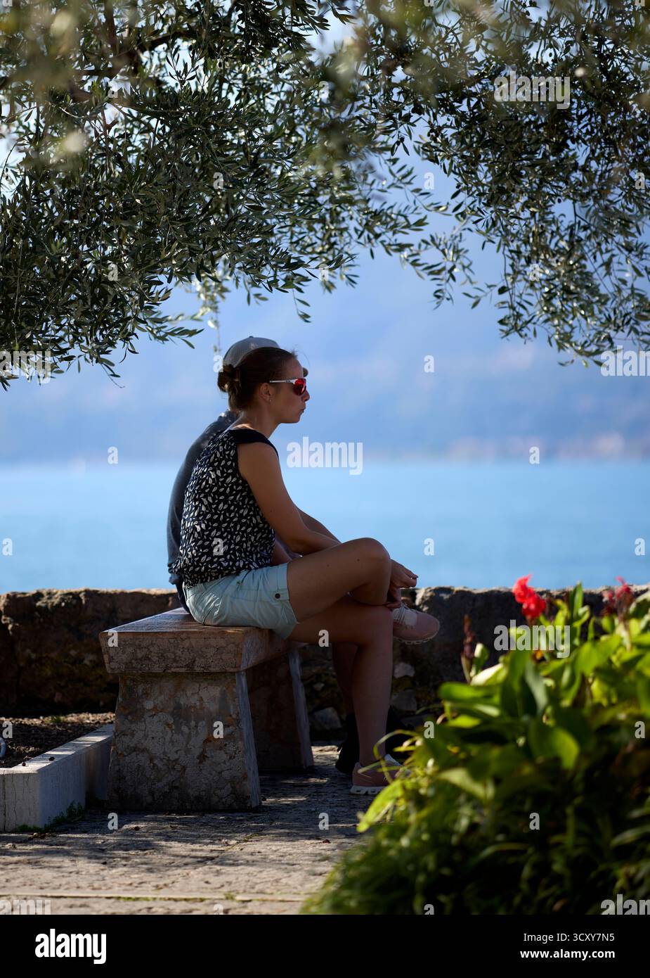 Couple relaxant au bord du lac, Torri del Benaco, Italie Banque D'Images