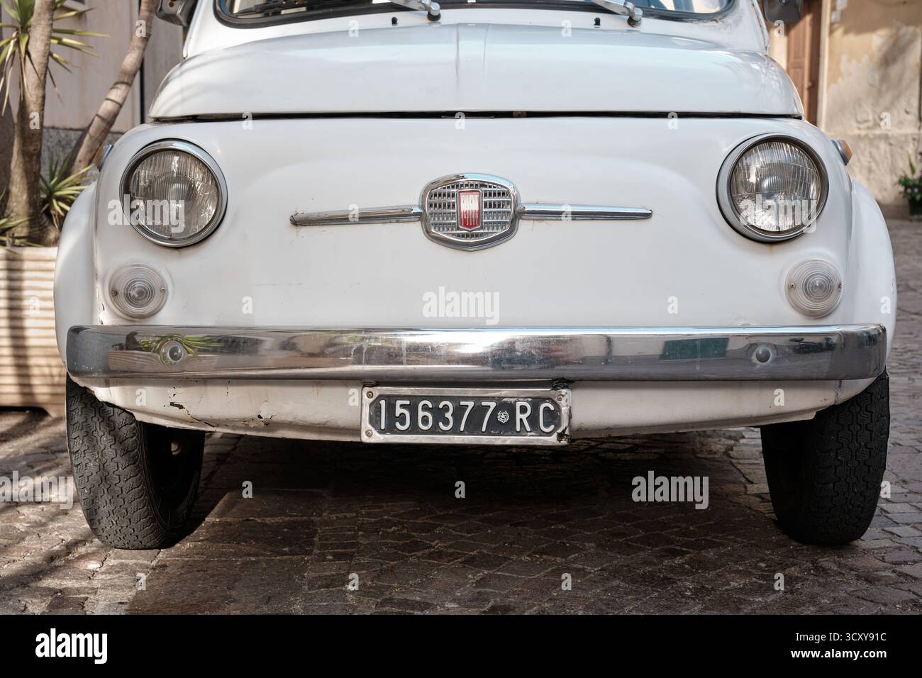 Scilla, Italie â€“ septembre 25, 2025 : détail de devant d’une Fiat 500 classique garée sur une rue pavée dans le sud de l’Italie. Banque D'Images