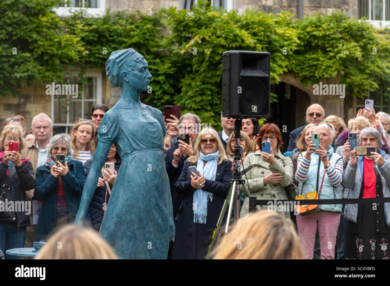 Winchester, Hampshire, Angleterre, Royaume-Uni. 16 octobre 2025. Une nouvelle statue de Jane Austen a été dévoilée cet après-midi. La nouvelle œuvre d'art est placée contre le n ° 9 le proche à côté de la cathédrale de Winchester. La statue montre l'auteur debout à côté de son célèbre bureau. Cette année marque le 250e anniversaire de sa naissance. La cérémonie de dévoilement comprenait des discours du révérend Canon Dr Roland Riem, du sculpteur Martin Jennings et du Lord Lieutenant Nigel Atkinson Esq. Banque D'Images
