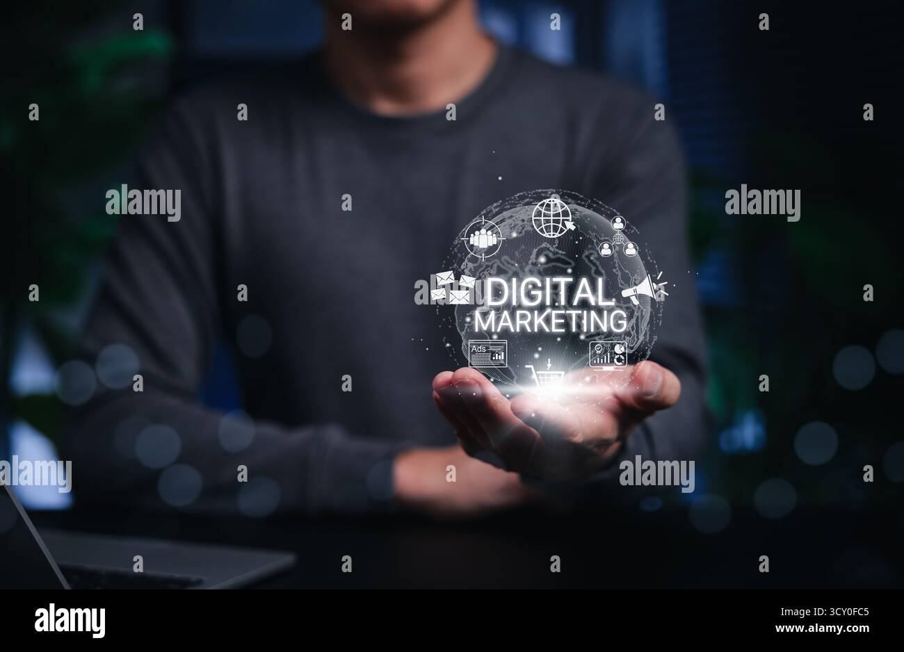 Concept de marketing numérique. Personne tenant un globe lumineux et des icônes numériques comme le courrier électronique, le panier, les publicités, les analyses et les outils de communication. Banque D'Images