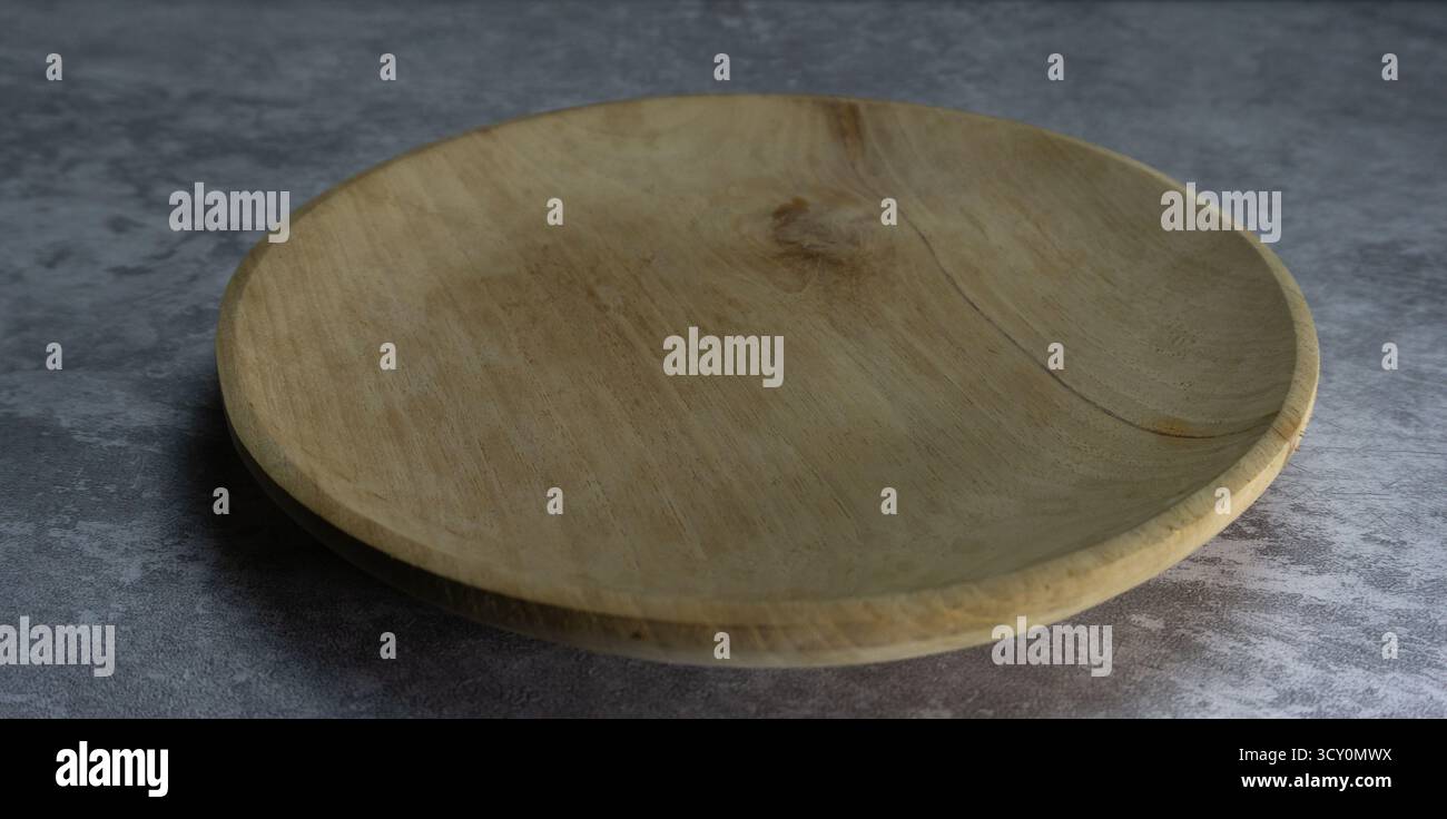 Plaque en bois ronde sur fond gris neutre, élément de style alimentaire rustique avec matière organique, composition plate pour le contenu culinaire Banque D'Images