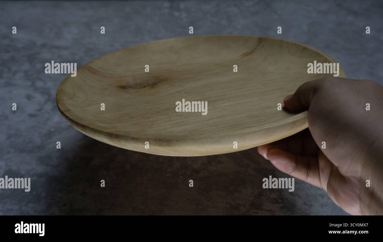 Plaque en bois ronde sur fond gris neutre, élément de style alimentaire rustique avec matière organique, composition plate pour le contenu culinaire Banque D'Images