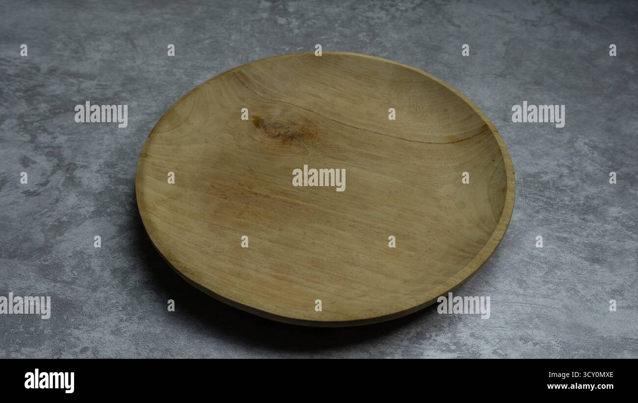 Plaque en bois ronde sur fond gris neutre, élément de style alimentaire rustique avec matière organique, composition plate pour le contenu culinaire Banque D'Images