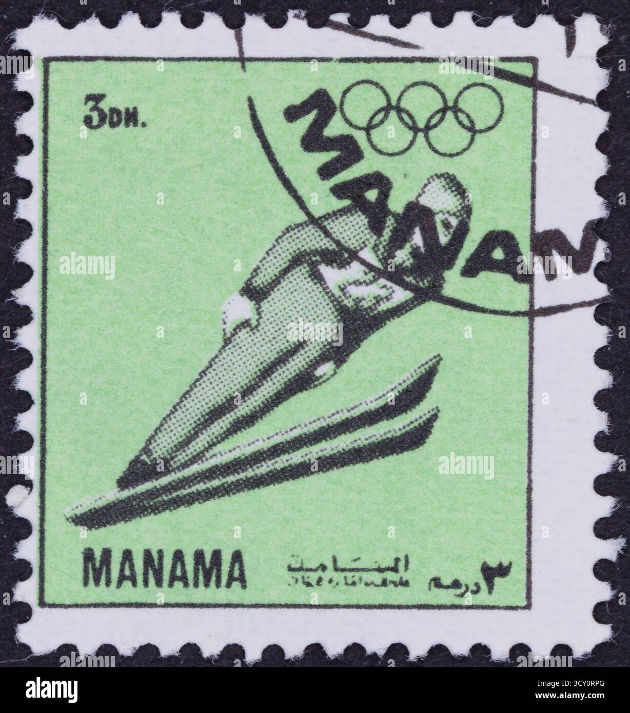 Un timbre-poste vert représente en noir et blanc un sauteur à ski en plein air, avec des anneaux olympiques au-dessus et du texte ci-dessous. Banque D'Images