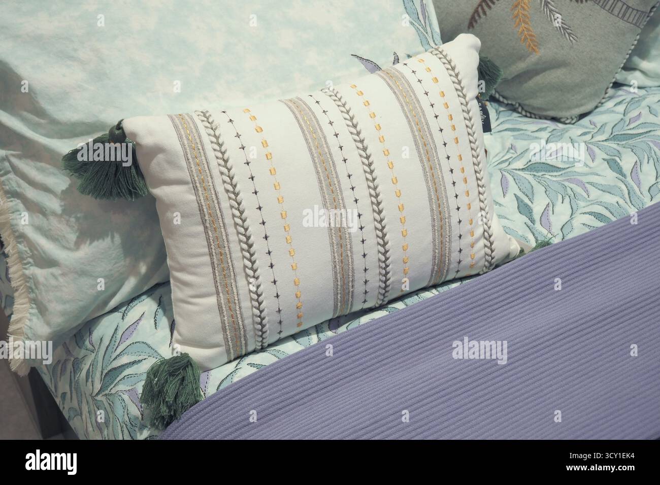 Coussin élégant sur un lit soigneusement fait dans une chambre confortable Banque D'Images