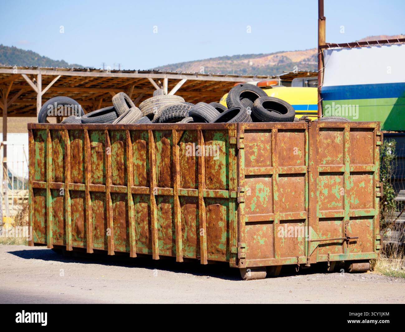 Grande poubelle débordante remplie de pneus usés Banque D'Images