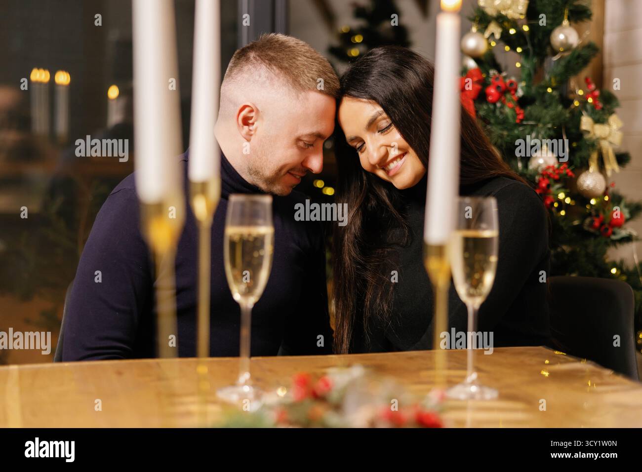 Couple profitant d'un dîner romantique avec des bougies et du champagne, créant une atmosphère chaleureuse et festive Banque D'Images Couple profitant d'un dîner romantique avec des bougies et du champagne, créant une atmosphère chaleureuse et festive Banque D'Images