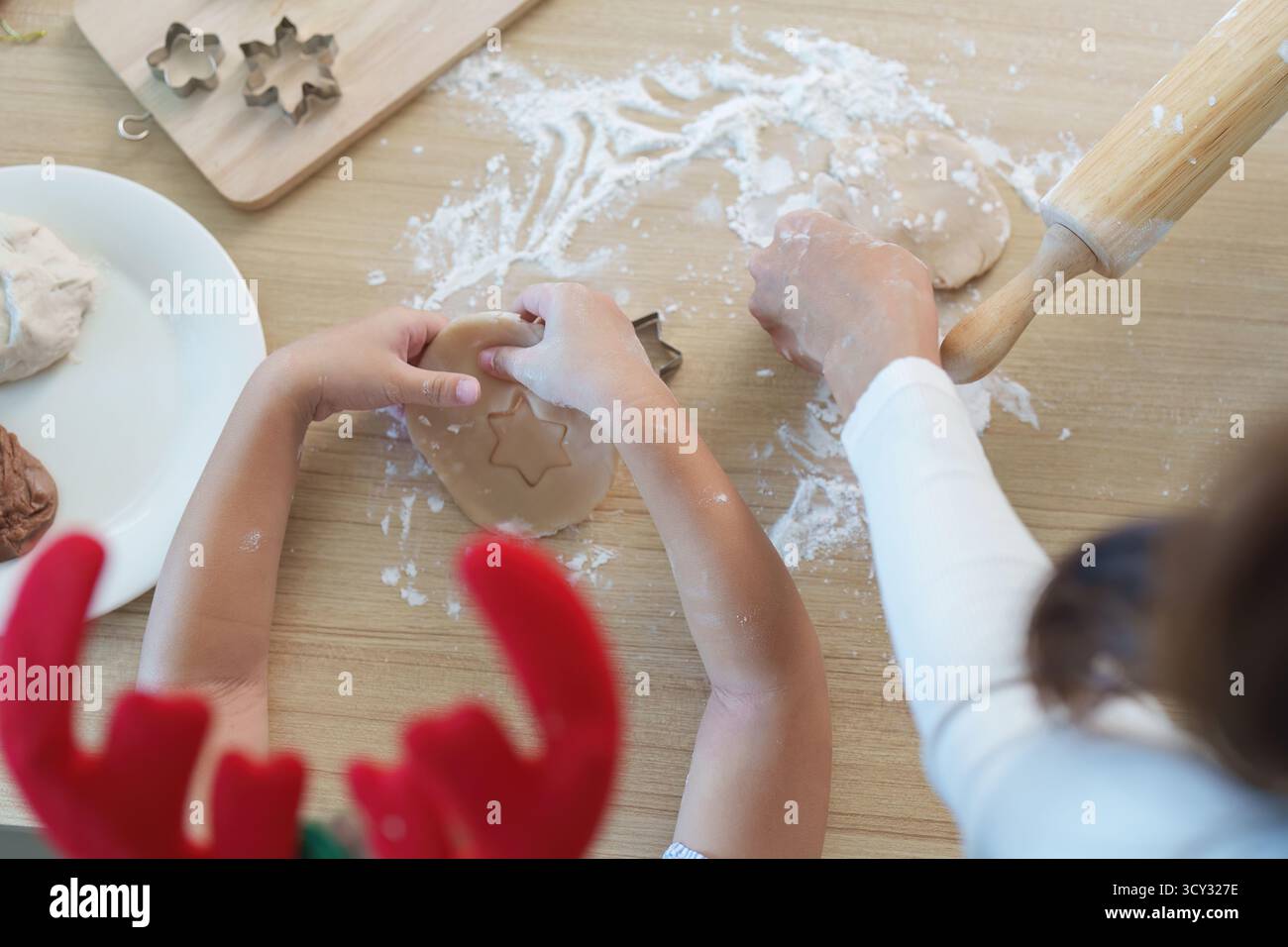Fabrication de biscuits de Noël. Une mère et un enfant utilisant des emporte-pièces pour des friandises festives. Banque D'Images