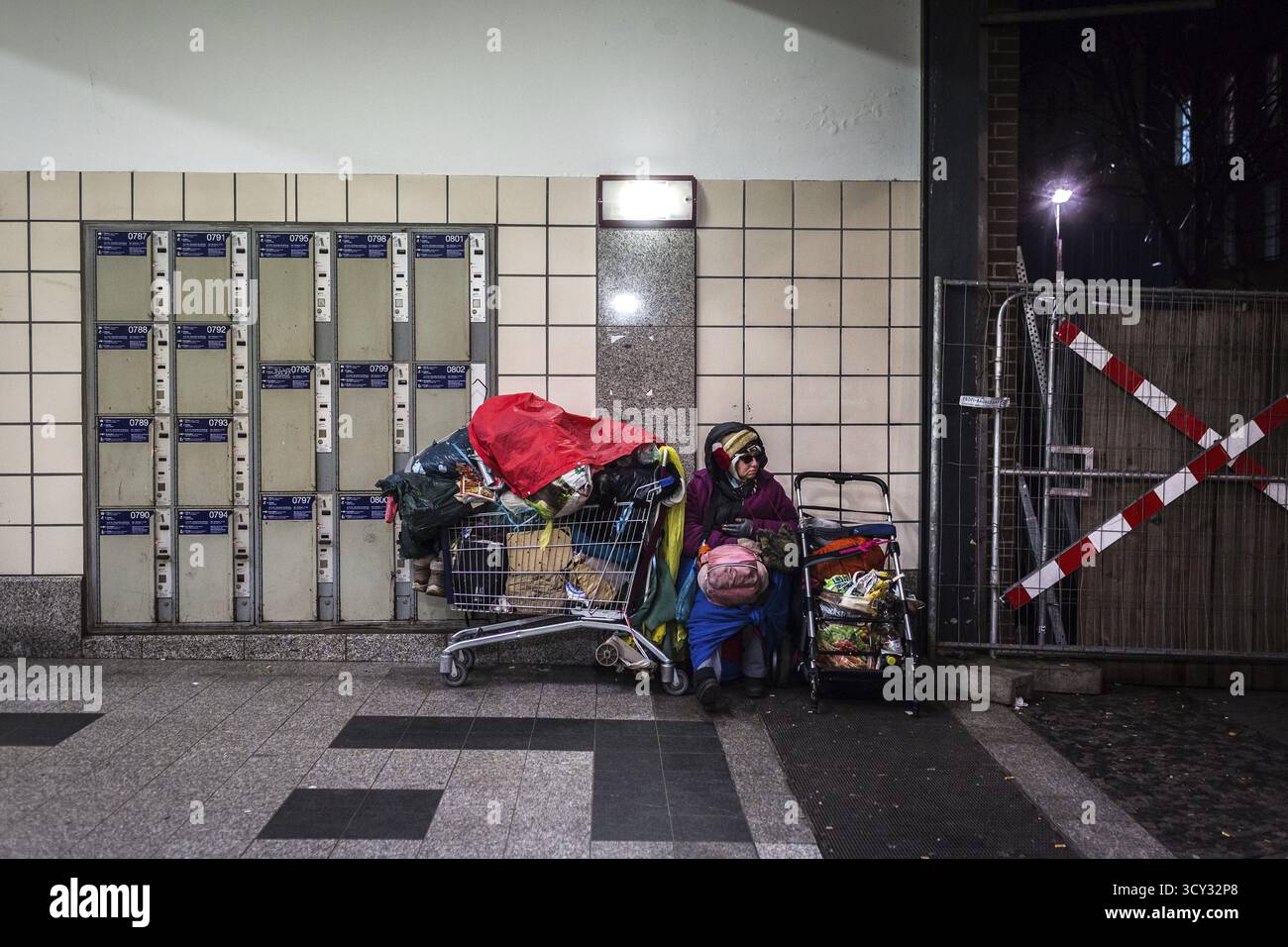 DEU Allemagne Berlin scènes de sans-abri autour du zoo de Bahnhof. Femme avec ses effets personnels assis à côté des casiers Banque D'Images