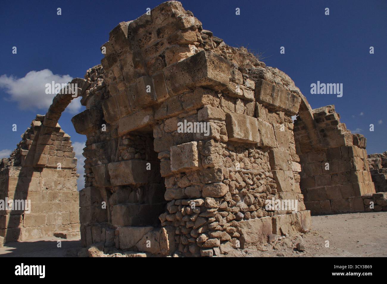 Les restes d'anciennes structures en pierre sont éclairés par la lumière du soleil contre un ciel bleu vif. Ce site évoque un sens de l'histoire et de l'architecture Banque D'Images