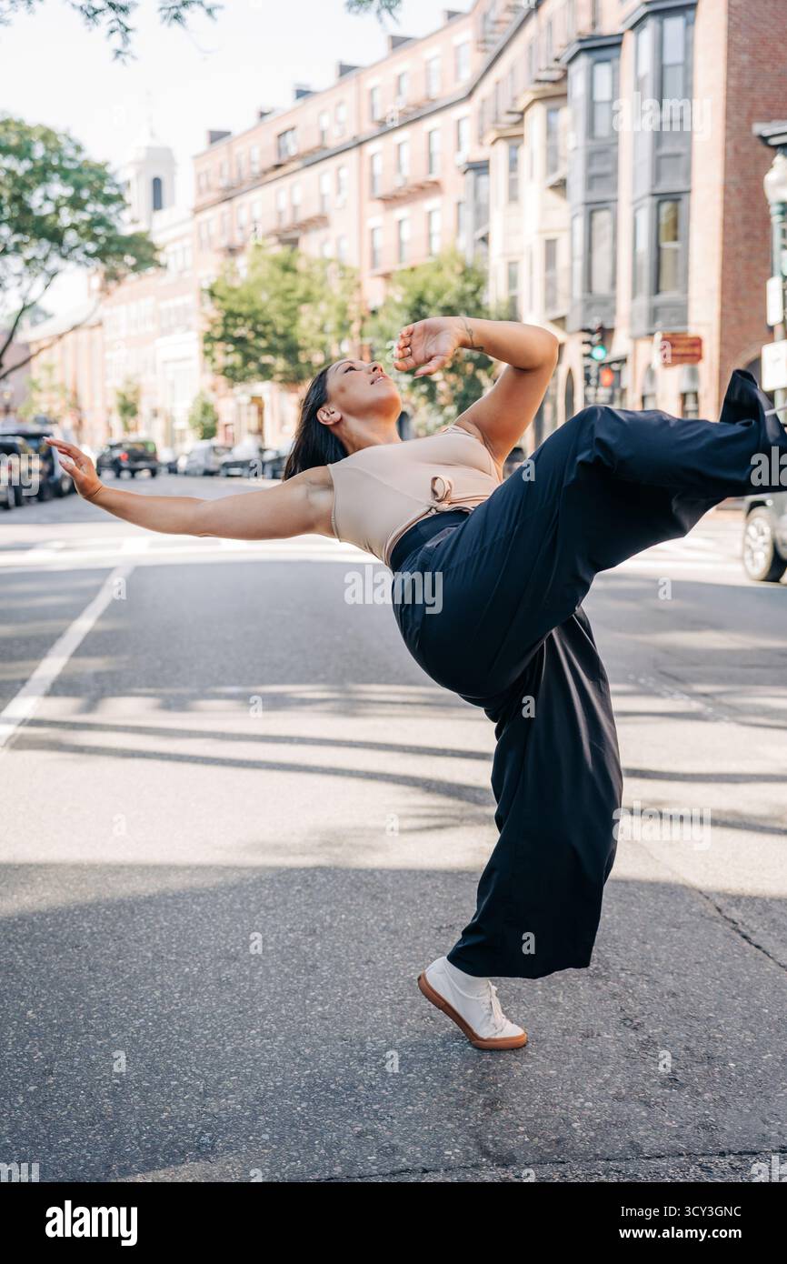 Danseuse féminine exprimant la liberté et le mouvement dans la rue urbaine Banque D'Images