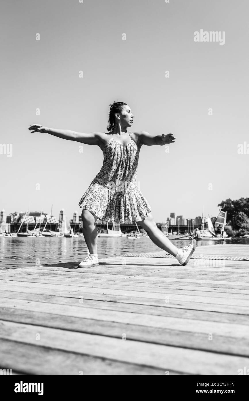 Femme frappe forte pose de danse sur le quai en noir et blanc Banque D'Images