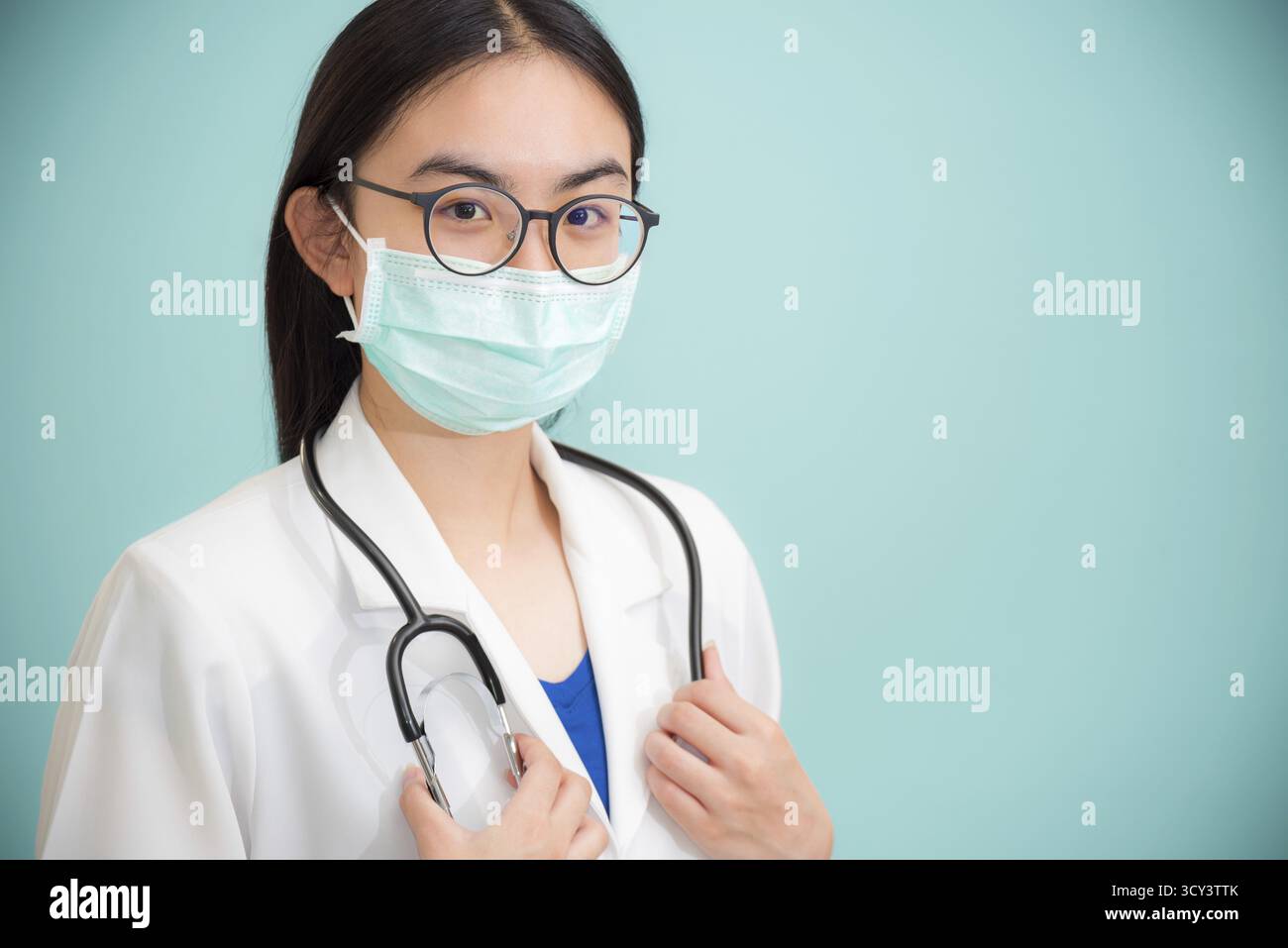 Studio portrait beau médecin de jeune femme asiatique avec stéthoscope en lunettes de soleil uniformes blanches et masque vert pour protéger Corona virus for Health lo Banque D'Images