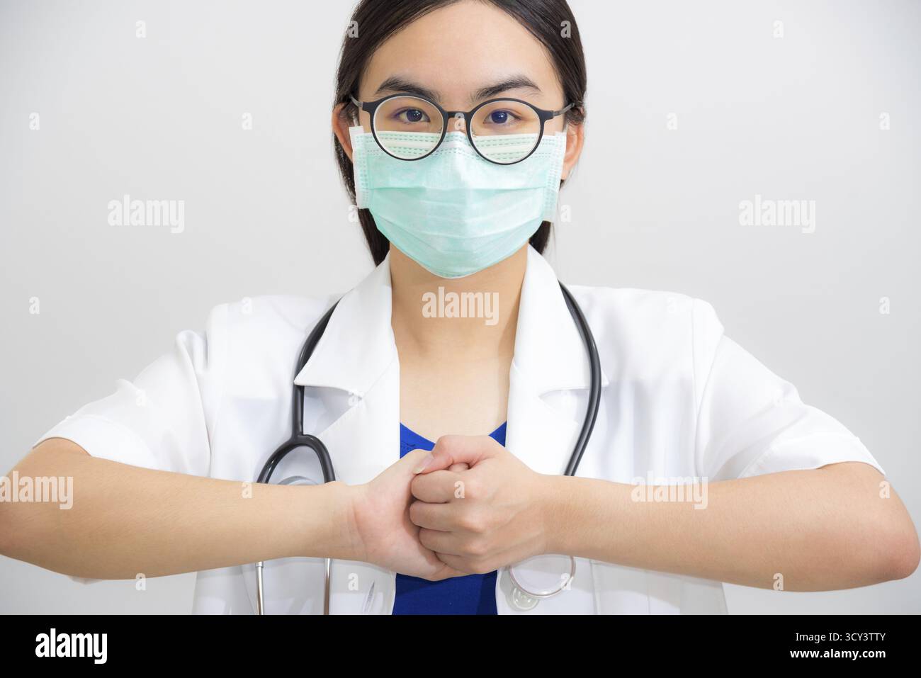 Portrait beau médecin asiatique avec stéthoscope et masque pour protéger Corona virus clasp geste de main de mendier pour aider la coopération, travailler ensemble Banque D'Images